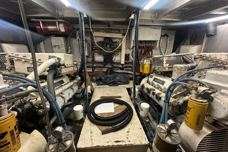 Slide: The Image of Engine room of a 1991 Carver Californian 48 yacht, featuring dual engines and mechanical components. - 69
