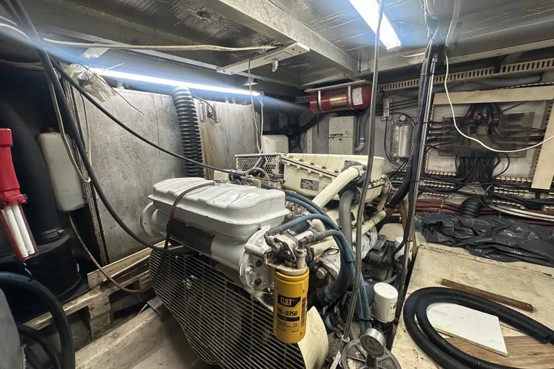Slide: The Image of Engine room of a 1991 Carver Californian 48 yacht, showcasing mechanical components and wiring. - 70