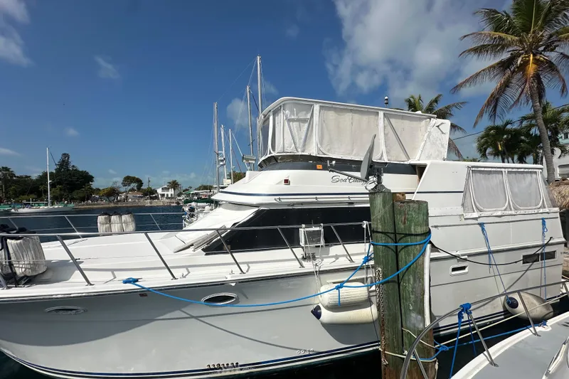 The Image of 1991 Carver Californian 48 yacht docked, featuring white exterior and covered upper deck. - 0