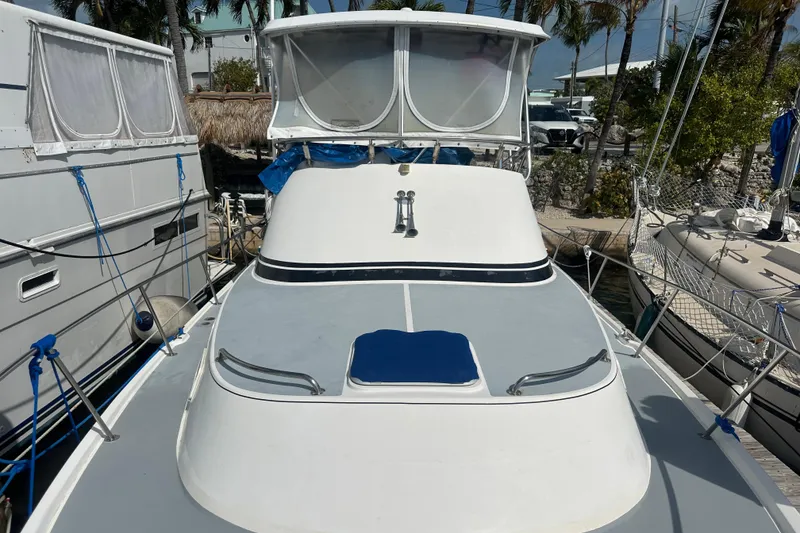 Slide: The Image of 1991 Carver Californian 48 yacht docked, featuring sleek design and spacious deck. - 11