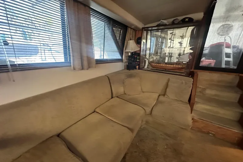 Slide: The Image of Cozy interior of 1991 Carver Californian 48 yacht with beige sofa and model ship display. - 36