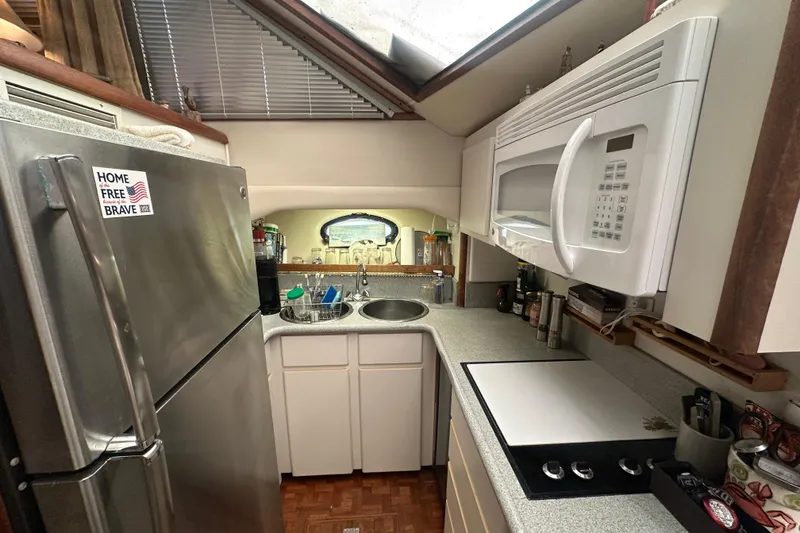 Slide: The Image of Compact kitchen in a 1991 Carver Californian 48 yacht with modern appliances. - 49