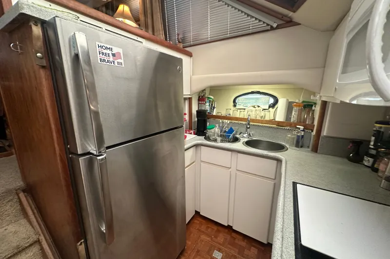Slide: The Image of 1991 Carver Californian 48 yacht kitchen with stainless steel fridge and compact sink area. - 51