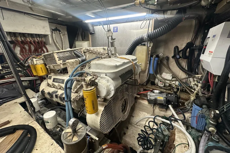Slide: The Image of Engine room of a 1991 Carver Californian 48 yacht, showcasing mechanical components and wiring. - 68