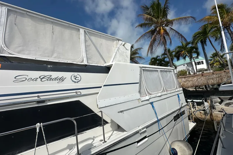 Slide: The Image of 1991 Carver Californian 48 yacht docked, featuring "Sea Caddy" name, palm trees in background. - 9