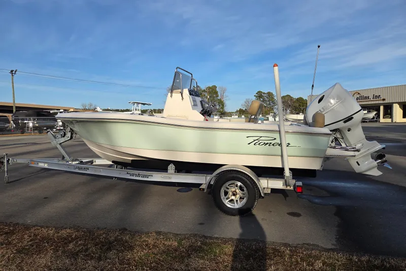 Slide: The Image of 2020 Pioneer 180 Islander boat on trailer, parked outdoors under clear sky. - 5
