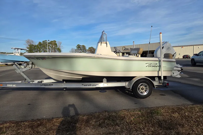 Slide: The Image of 2020 Pioneer 180 Islander boat on trailer, parked outdoors under clear sky. - 6