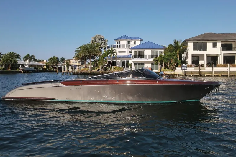 The Image of 2025 Riva 33' Aquariva Special yacht cruising near waterfront homes. - 0