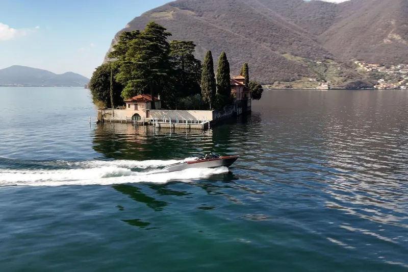 Slide: The Image of Speedboat cruising near a picturesque island with lush greenery and mountains, 2025 Riva model. - 10