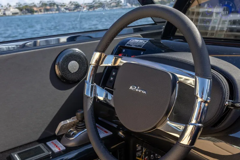 Slide: The Image of Steering wheel of 2025 Riva 33' Aquariva Special boat, with sleek design and water view. - 12