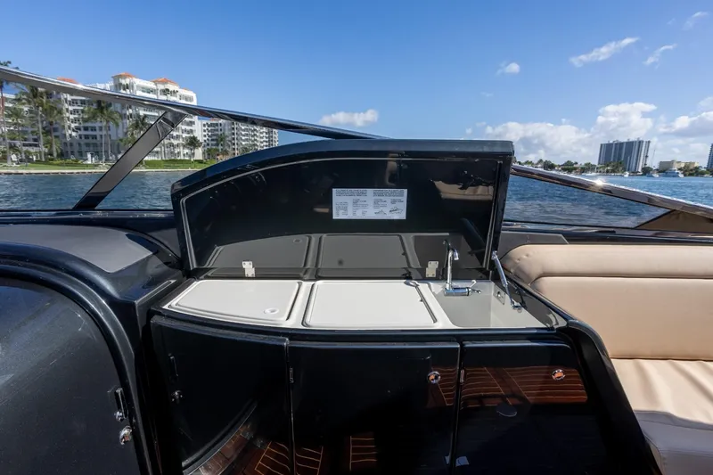 Slide: The Image of 2025 Riva 33' Aquariva Special yacht interior with sink and seating, overlooking waterfront buildings. - 15