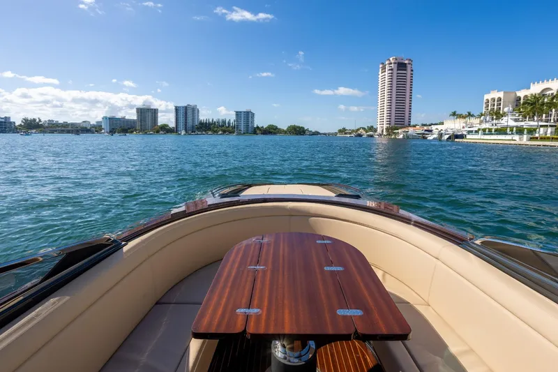Slide: The Image of 2025 Riva 33' Aquariva Special yacht cruising on a sunny waterfront with city skyline. - 19