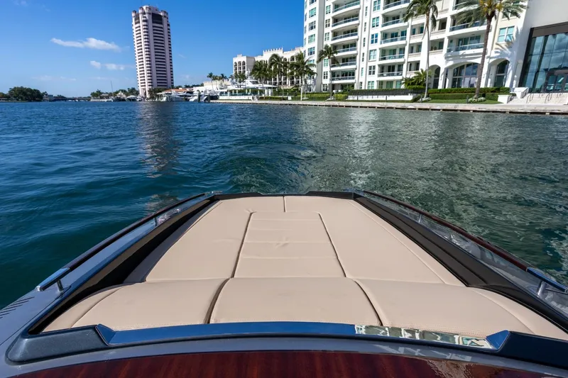 Slide: The Image of 2025 Riva 33' Aquariva Special cruising near luxury waterfront buildings. - 20