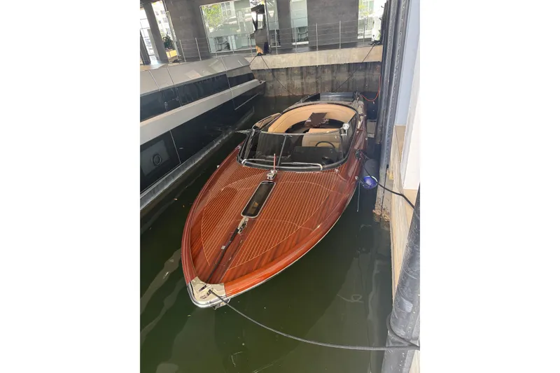 Slide: The Image of 2025 Riva boat with sleek wooden design docked in a marina. - 6