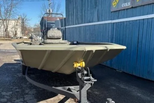 Slide: The Image of 2026 Tracker Grizzly 1860 CC boat on trailer, parked by blue building. - 2