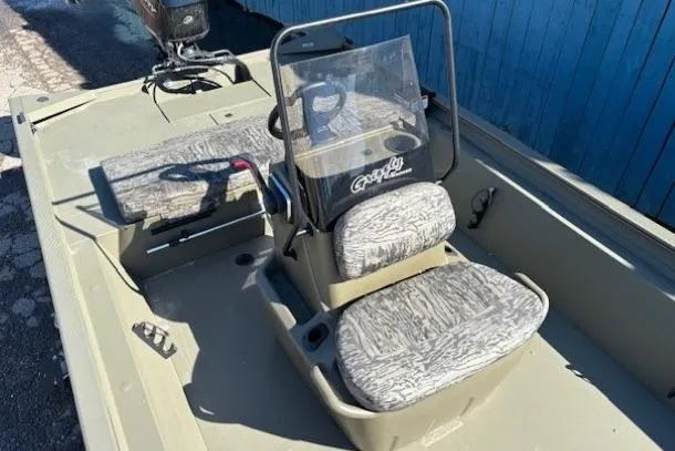 Slide: The Image of 2026 Tracker Grizzly 1860 CC boat interior with camouflage seating and steering console. - 6