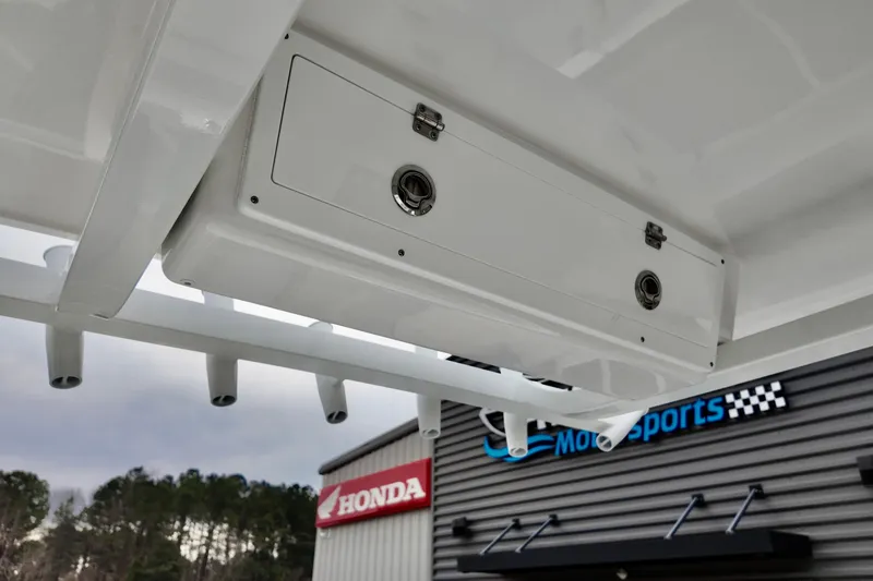 Slide: The Image of 2026 Sea Fox 268 Commander boat storage compartment, with dealership signage in background. - 3
