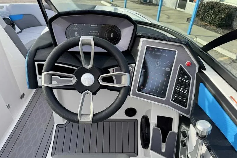Slide: The Image of 2023 MasterCraft XT22 boat dashboard with steering wheel and digital controls. - 10