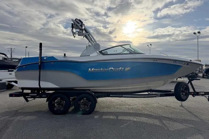 Slide: The Image of 2023 MasterCraft XT22 boat on trailer under cloudy sky. - 3