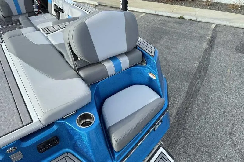 Slide: The Image of 2023 MasterCraft XT22 boat interior with blue and gray seating and cup holder. - 5