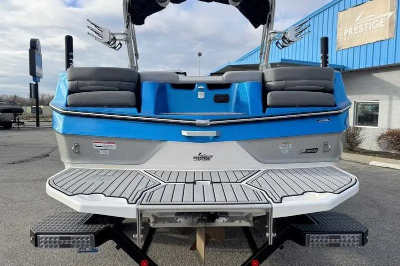 Slide: The Image of 2023 MasterCraft XT22 boat, blue and gray, rear view at dealership. - 9