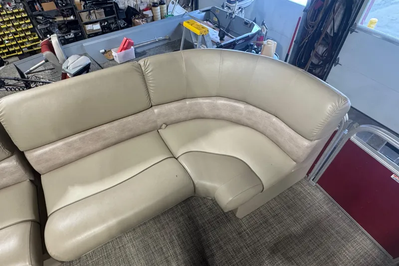 Slide: The Image of 2014 Bennington 2275 GL boat interior with beige seating in a workshop setting. - 3