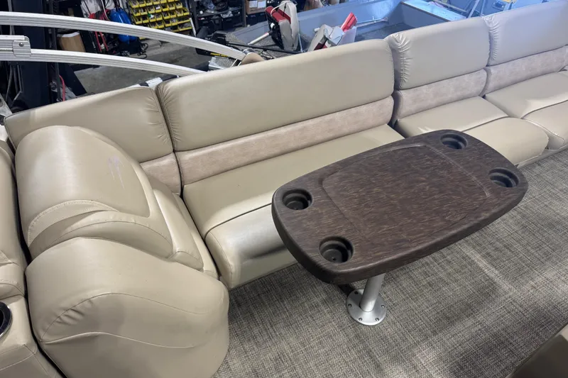 Slide: The Image of 2014 Bennington 2275 GL boat interior with beige seating and wooden table. - 6