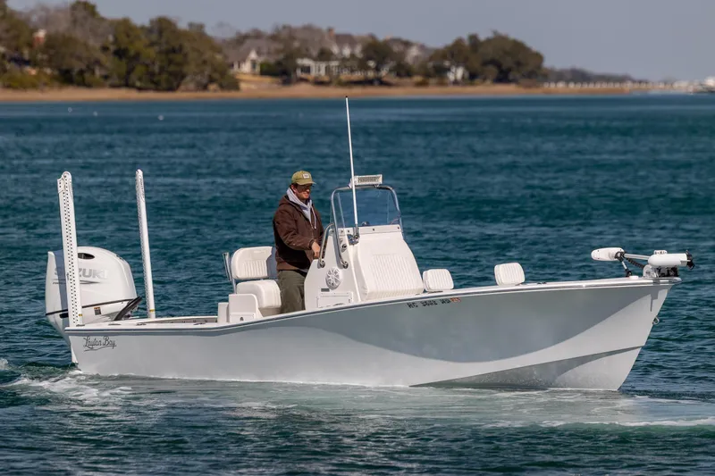 Slide: The Image of 2024 Layton Bay 22 boat cruising on clear blue water with a person at the helm. - 1
