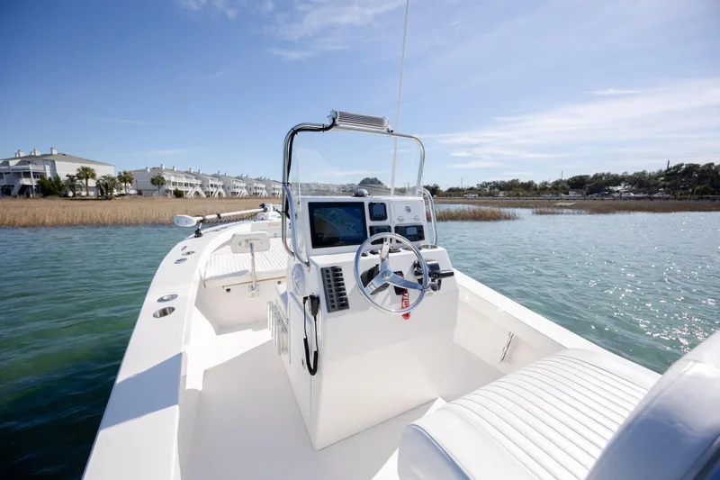 Slide: The Image of 2024 Layton Bay 22 boat on calm water, featuring sleek design and modern controls. - 14