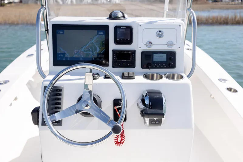 Slide: The Image of 2024 Layton Bay 22 boat console with steering wheel and navigation equipment. - 15