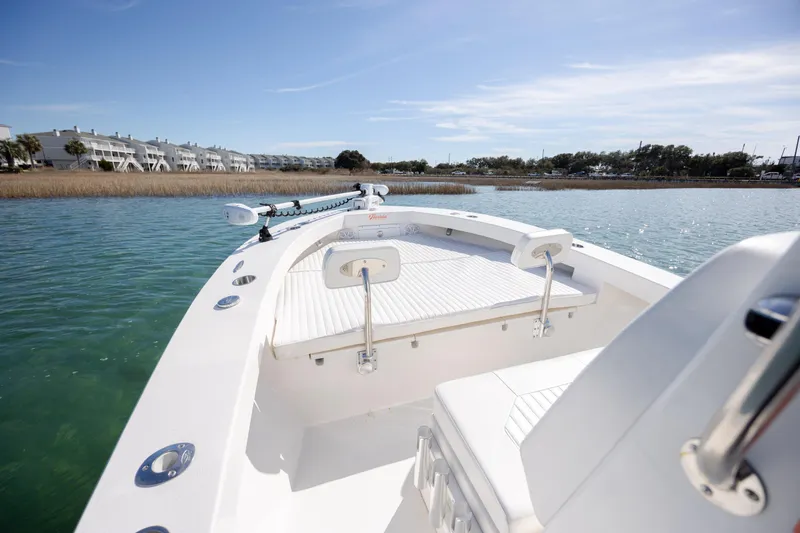Slide: The Image of 2024 Layton Bay 22 boat on calm water, showcasing sleek design and spacious deck. - 17