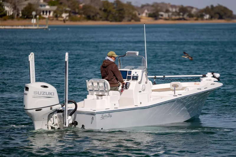 Slide: The Image of 2024 Layton Bay 22 boat with Suzuki engine cruising on a calm lake. - 6
