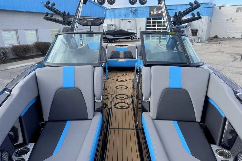 Slide: The Image of 2024 MasterCraft X24 boat interior with blue and gray seating, docked at a marina. - 11
