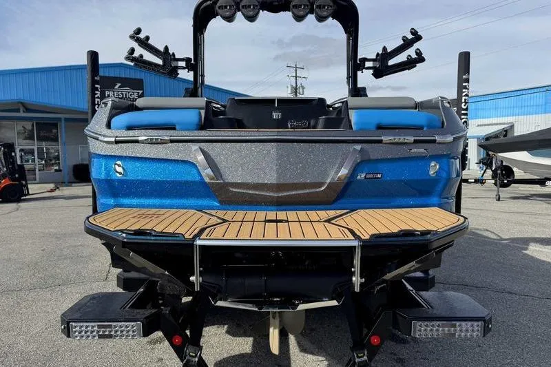 Slide: The Image of 2024 MasterCraft X24 boat, blue and silver, rear view with wooden deck. - 7