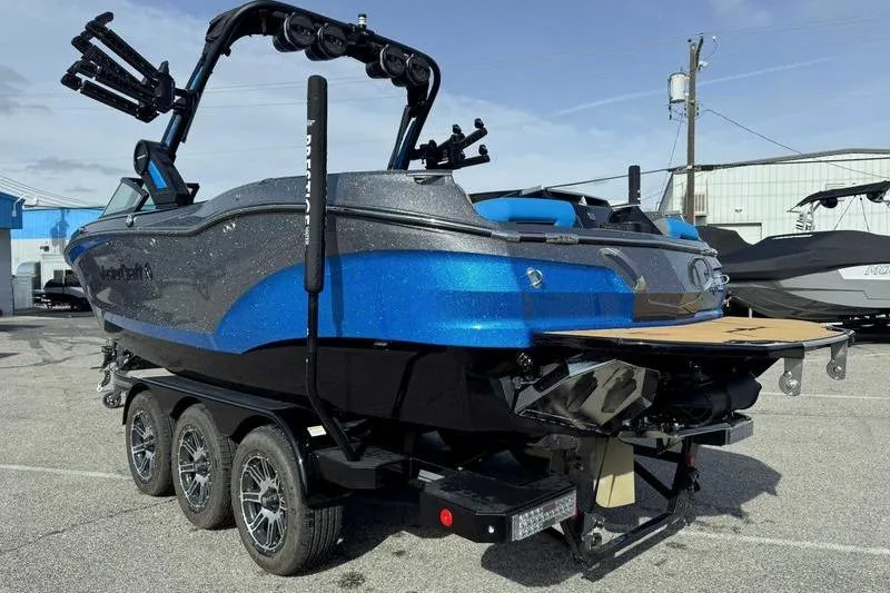 Slide: The Image of 2024 MasterCraft X24 boat on trailer, featuring sleek blue and gray design. - 8
