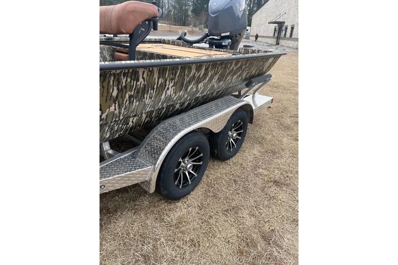 Slide: The Image of 2026 Avid 22 Rogue CC boat on trailer with camouflage design and dual wheels. - 11