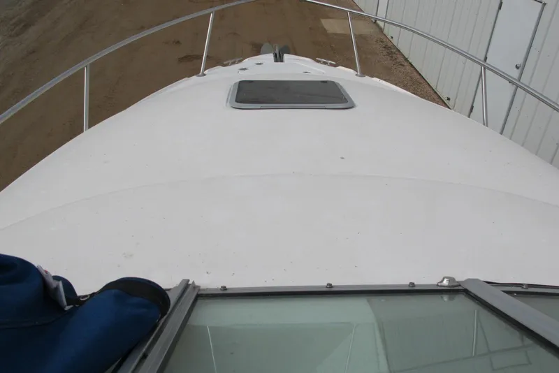 Slide: The Image of 2006 Chaparral Signature 240 boat deck with hatch, docked near a building. - 4