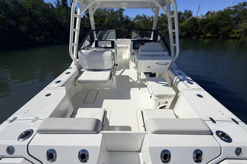 Slide: The Image of 2026 World Cat 265 DC-X boat interior with seating and console, docked on calm water. - 9