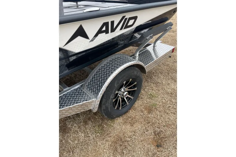 Slide: The Image of Avid 18 Vertex 2026 boat trailer with diamond plate fender on grass. - 5