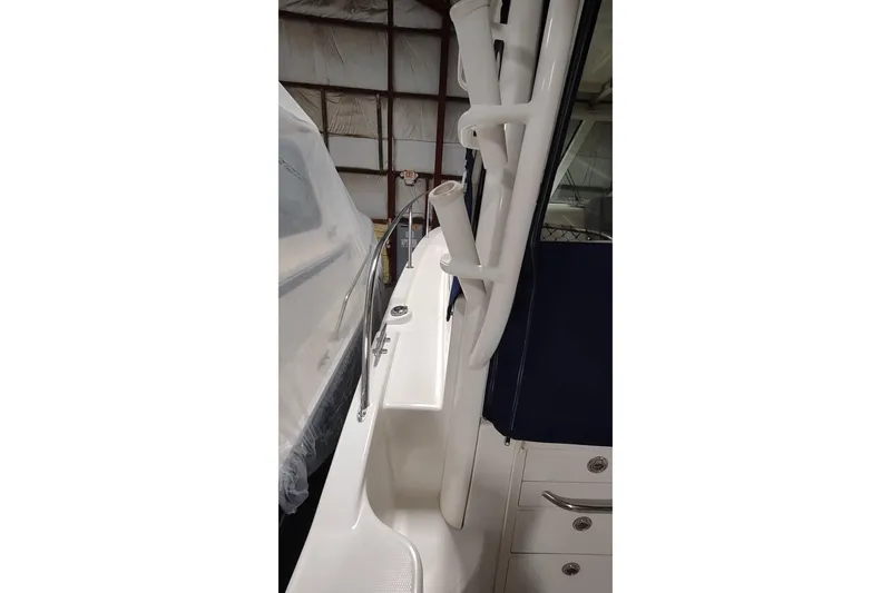 Slide: The Image of 2015 Boston Whaler 285 Conquest boat interior with rod holders and storage compartments. - 10