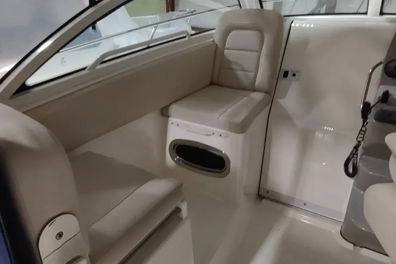 Slide: The Image of Interior of a 2015 Boston Whaler 285 Conquest boat, featuring cushioned seating. - 13