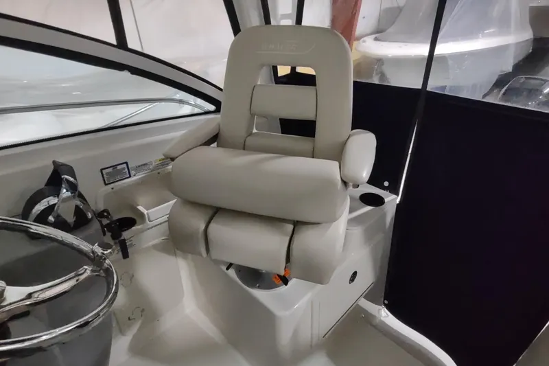 Slide: The Image of Captain's chair on 2015 Boston Whaler 285 Conquest boat, featuring comfortable seating and steering wheel. - 15