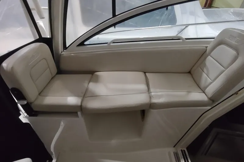 Slide: The Image of 2015 Boston Whaler 285 Conquest interior seating with beige cushions. - 26