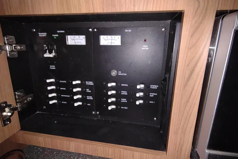 Slide: The Image of Electrical panel inside a 2015 Boston Whaler 285 Conquest boat, featuring various switches and indicators. - 37