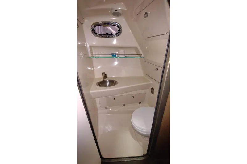 Slide: The Image of 2015 Boston Whaler 285 Conquest boat bathroom with sink, toilet, and storage cabinets. - 40