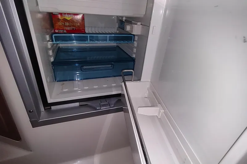 Slide: The Image of Open refrigerator on 2015 Boston Whaler 285 Conquest boat, showing coffee and storage drawers. - 41