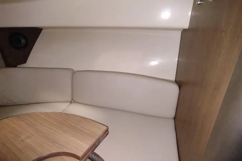 Slide: The Image of Interior of 2015 Boston Whaler 285 Conquest with cushioned seating and wooden table. - 43