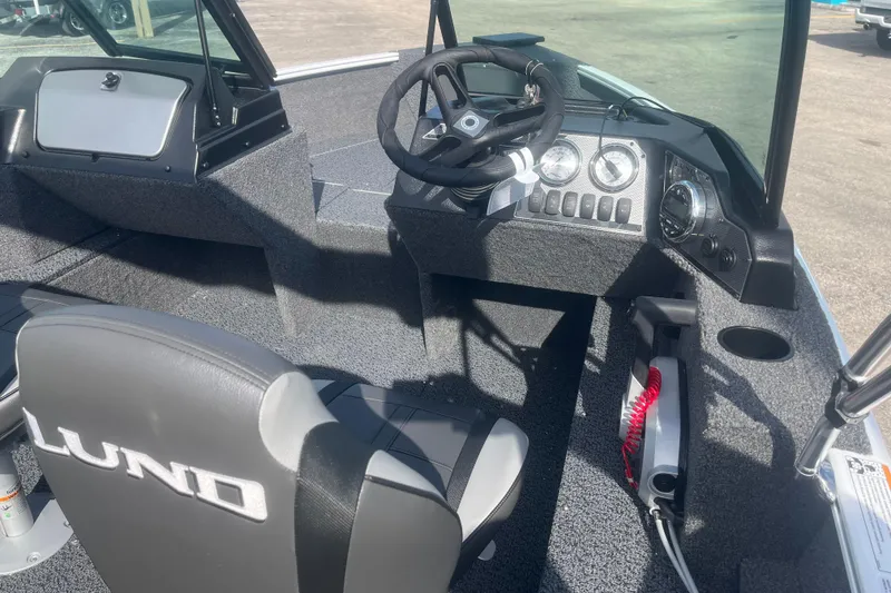Slide: The Image of 2026 Lund 1650 Rebel XL Sport boat interior with steering wheel and dashboard controls. - 10