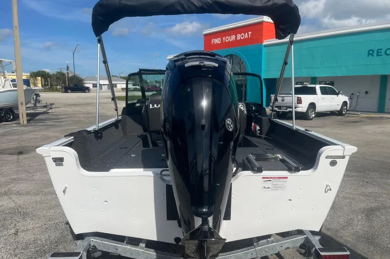 Slide: The Image of 2026 Lund 1650 Rebel XL Sport boat with outboard motor, parked outdoors. - 8