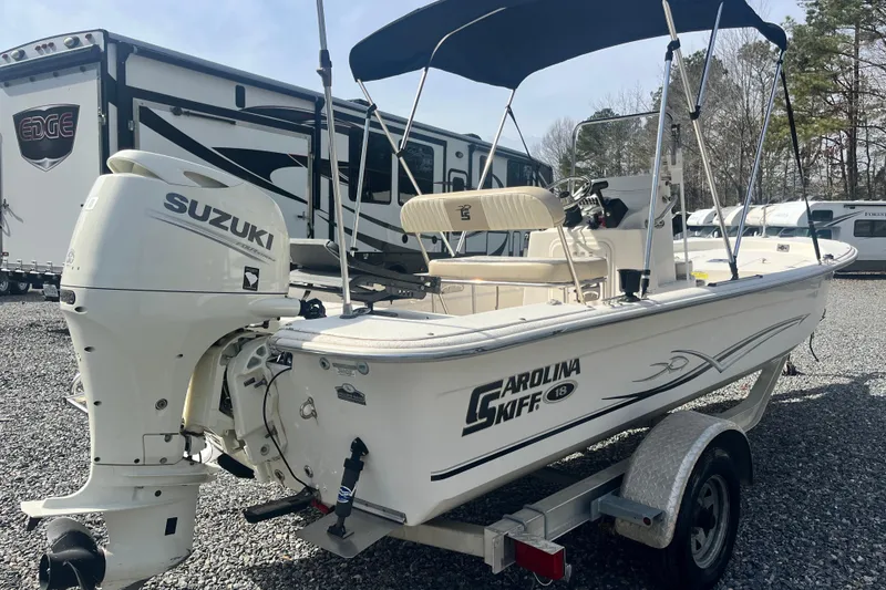 Slide: The Image of 2019 Carolina Skiff 18 JVX SS boat with Suzuki outboard motor on trailer. - 2